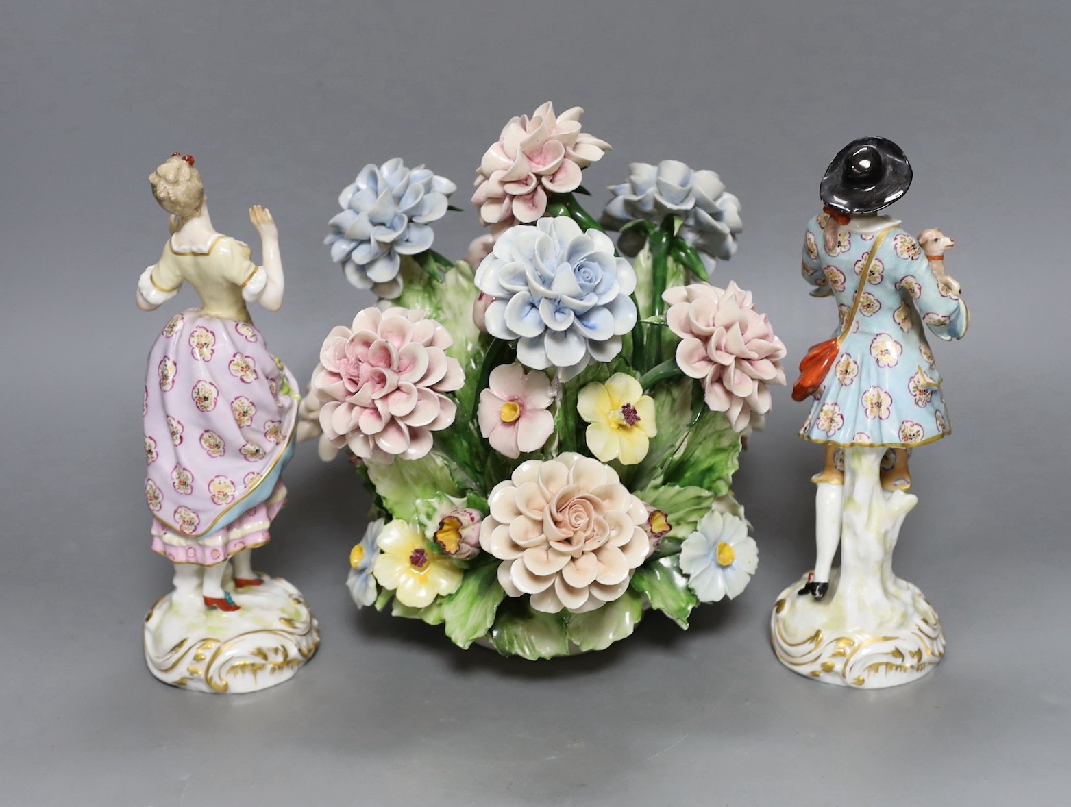 A pair of Continental porcelain figures and a Naples flowers bouquet. 22cm tall